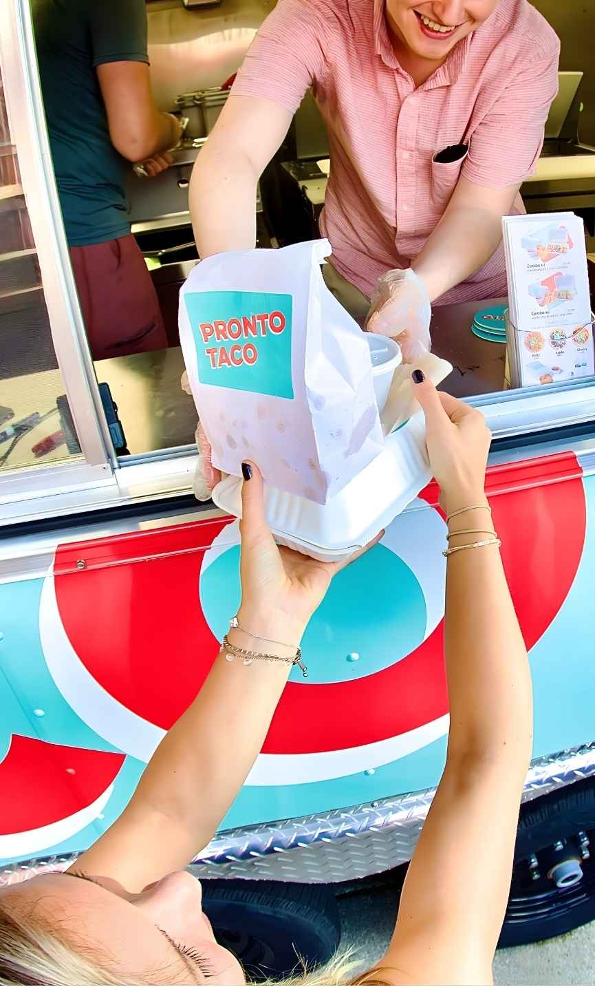 Pronto Taco food truck serving tacos hot off the grill at an event